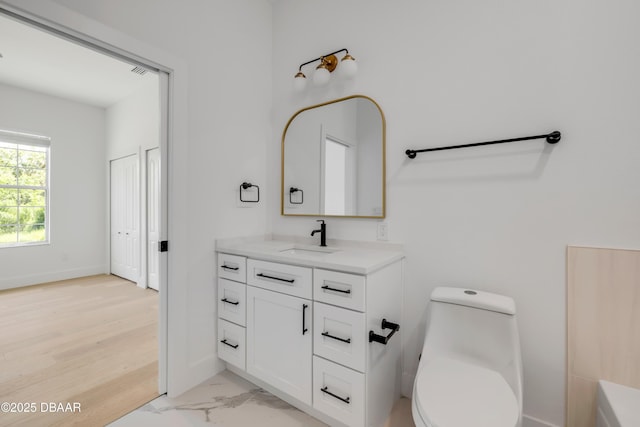 bathroom with vanity, marble finish floor, baseboards, toilet, and visible vents