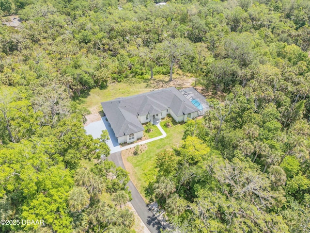 bird's eye view with a wooded view