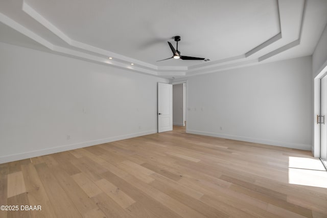 unfurnished bedroom featuring light wood finished floors, baseboards, recessed lighting, and a raised ceiling