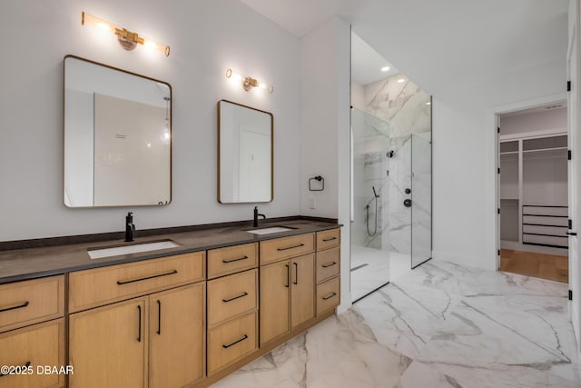 full bathroom with marble finish floor, a sink, a marble finish shower, and double vanity
