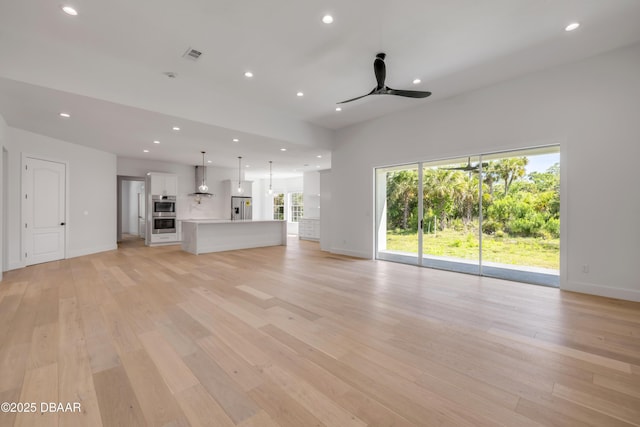 unfurnished living room with light wood-type flooring, visible vents, and recessed lighting