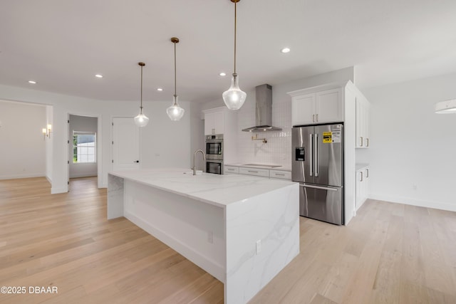 kitchen featuring baseboards, white cabinetry, appliances with stainless steel finishes, and wall chimney range hood