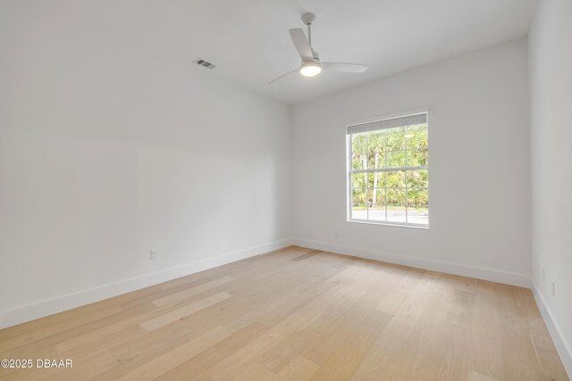 unfurnished room with baseboards, a ceiling fan, visible vents, and light wood-style floors