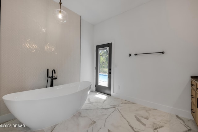 bathroom with baseboards, a freestanding tub, marble finish floor, and vanity
