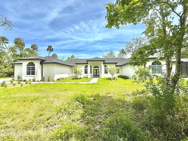 view of front of home featuring stucco siding and a front yard