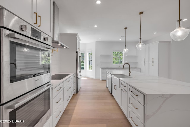 kitchen with white cabinets, recessed lighting, light wood finished floors, open shelves, and appliances with stainless steel finishes