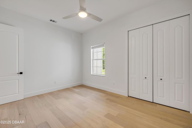 unfurnished bedroom with visible vents, light wood-type flooring, a closet, baseboards, and ceiling fan
