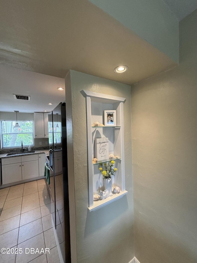 65 Seton Trl Unit 8, Ormond Beach, FL 32176 - kitchen with a textured wall, recessed lighting, dark countertops, light tile patterned floors, and white cabinetry