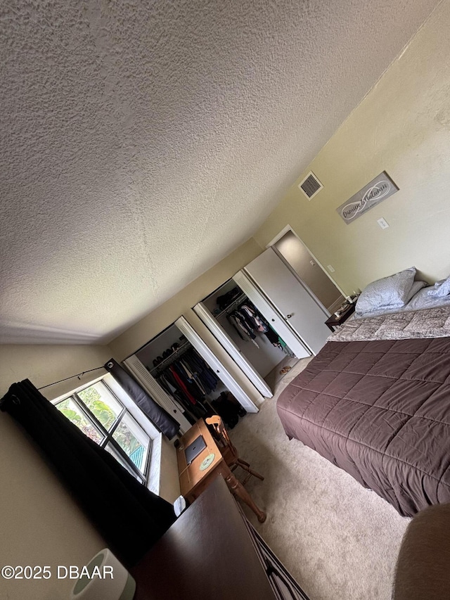 65 Seton Trl Unit 8, Ormond Beach, FL 32176 - carpeted bedroom featuring a textured ceiling and vaulted ceiling