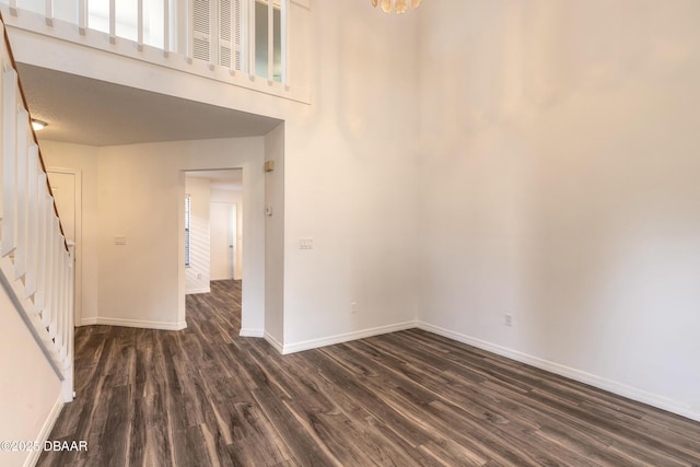 unfurnished room with dark wood-type flooring