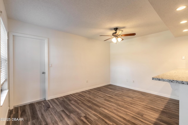 spare room featuring a textured ceiling, ceiling fan, and dark hardwood / wood-style flooring