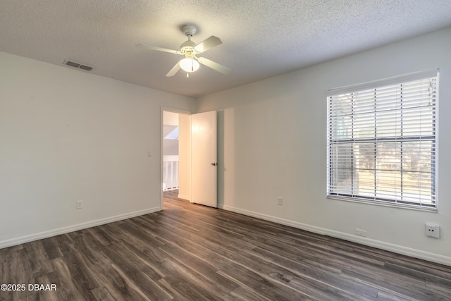 empty room with a textured ceiling, dark wood-type flooring, and ceiling fan