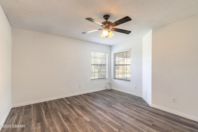 empty room featuring ceiling fan, dark wood-type flooring, and a textured ceiling