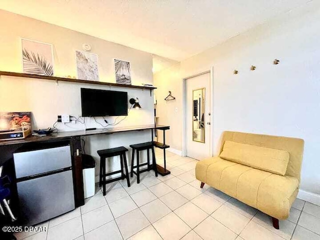 living area with baseboards and light tile patterned floors