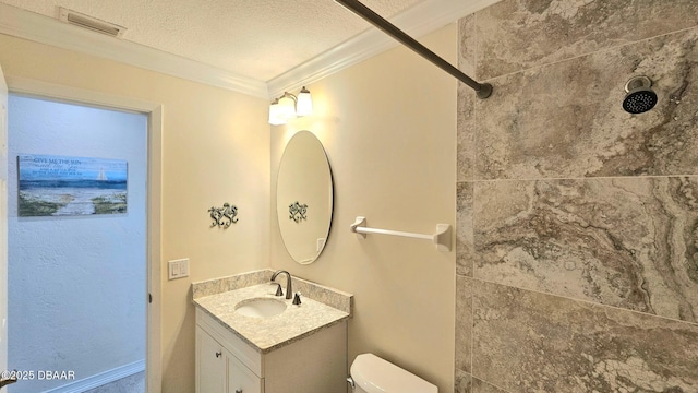 bathroom featuring vanity, ornamental molding, toilet, and a textured ceiling