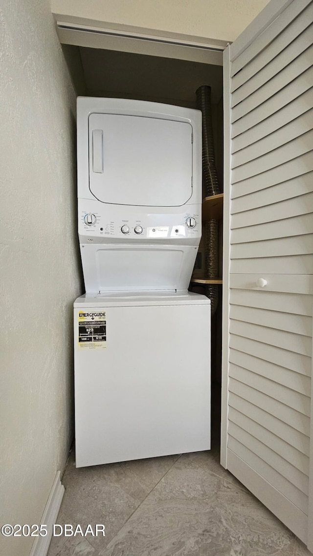 clothes washing area with stacked washer and dryer