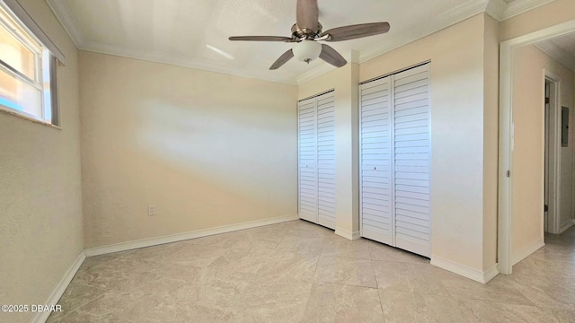 unfurnished bedroom with two closets, ornamental molding, and ceiling fan