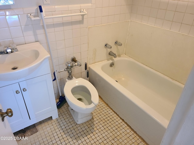 bathroom with tile patterned floors, vanity, toilet, and tile walls