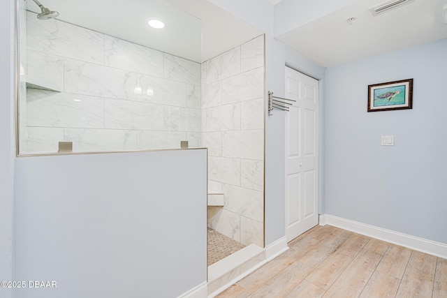 bathroom with baseboards, visible vents, wood finished floors, walk in shower, and recessed lighting