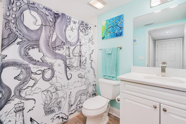 bathroom featuring visible vents, vanity, toilet, and wood finished floors