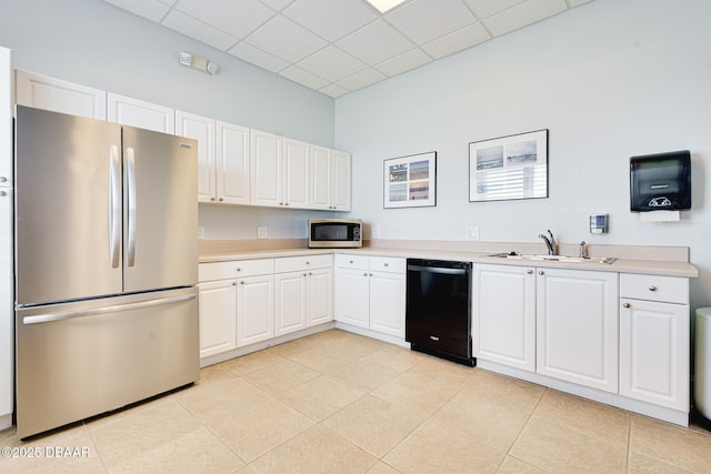 kitchen with light countertops, appliances with stainless steel finishes, a sink, and white cabinetry