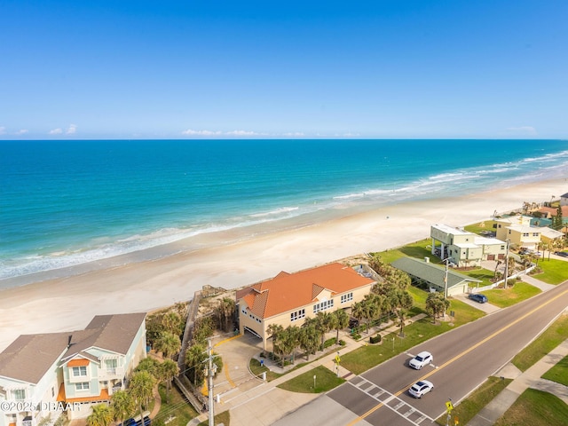 drone / aerial view with a residential view, a water view, and a beach view