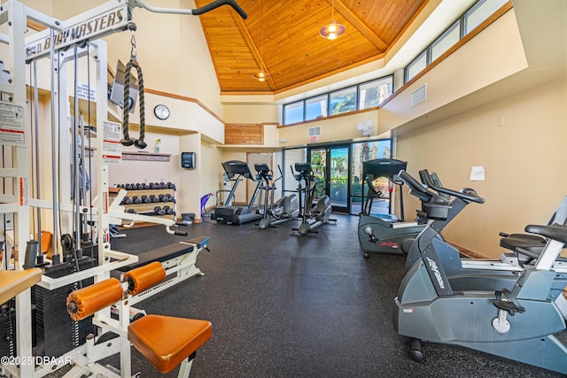 exercise room with visible vents, a towering ceiling, and wood ceiling