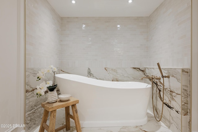 4545 S Atlantic Ave Unit 3604, Ponce Inlet, FL 32127 - bathroom featuring tile walls, marble tiled flooring, a freestanding tub, and recessed lighting