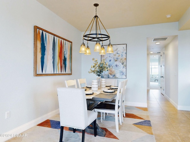 dining space featuring a notable chandelier and light tile patterned flooring