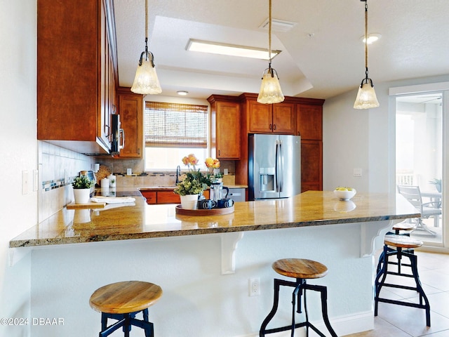 kitchen featuring a breakfast bar, decorative backsplash, stainless steel appliances, and kitchen peninsula