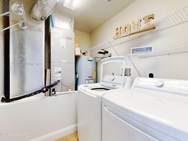 laundry area with washing machine and clothes dryer, light tile patterned floors, and water heater