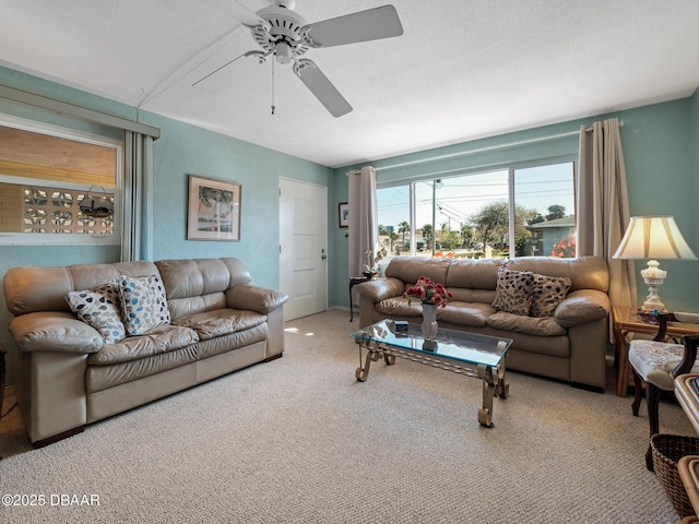 carpeted living area with a ceiling fan