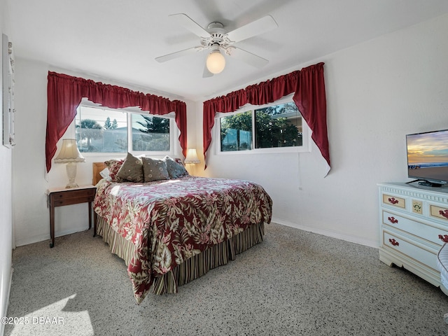 bedroom featuring multiple windows, baseboards, and ceiling fan