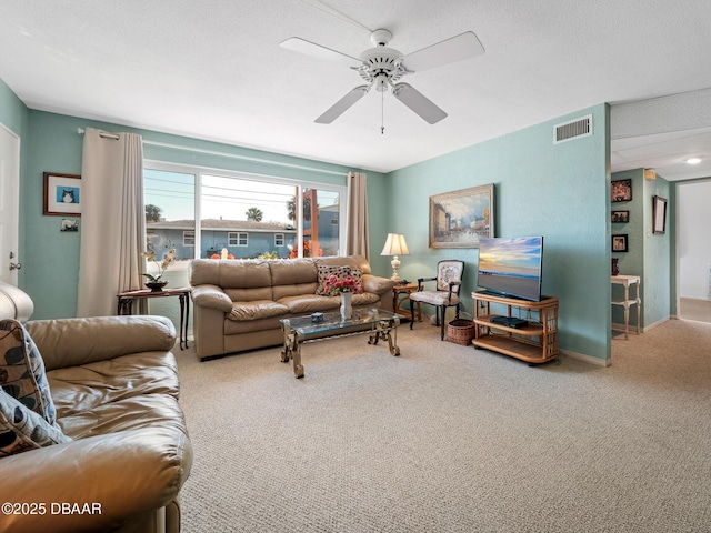 living room featuring carpet flooring, visible vents, and ceiling fan