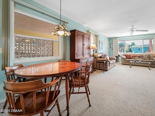 dining area with light colored carpet and ceiling fan