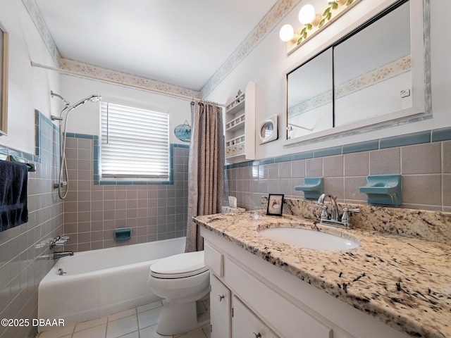 bathroom featuring tile patterned flooring, toilet, vanity, shower / bath combo, and tile walls