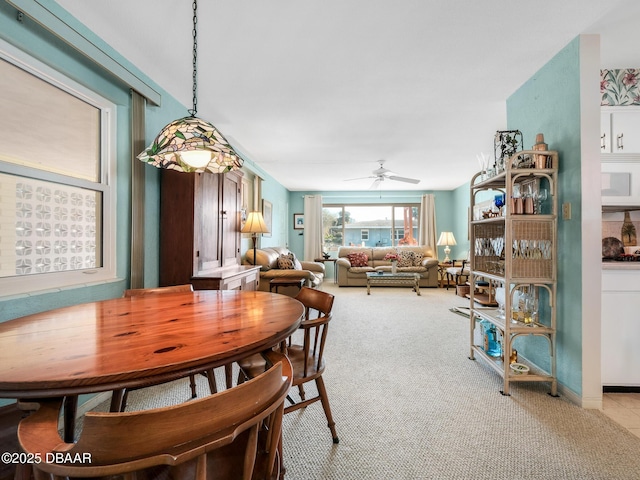 dining area featuring light carpet and a ceiling fan