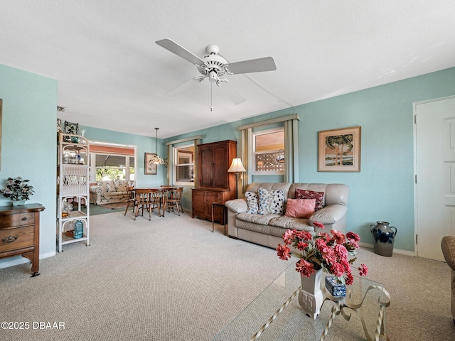 carpeted living room with baseboards and ceiling fan