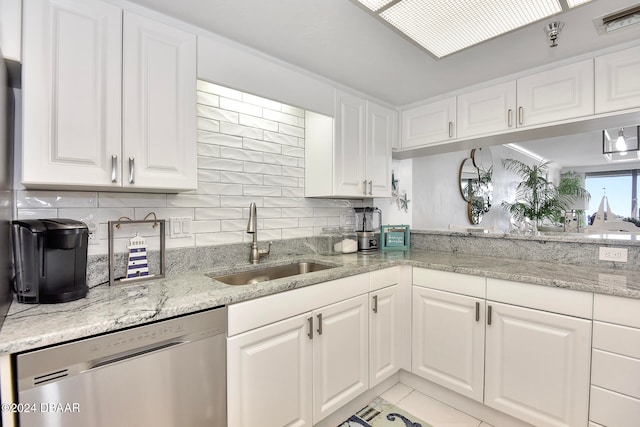 kitchen featuring white cabinets, dishwasher, light stone counters, and sink