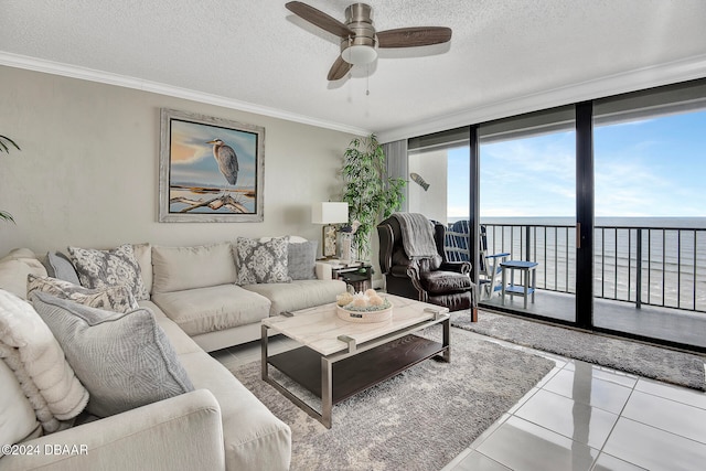 tiled living room with a water view, a textured ceiling, and ornamental molding