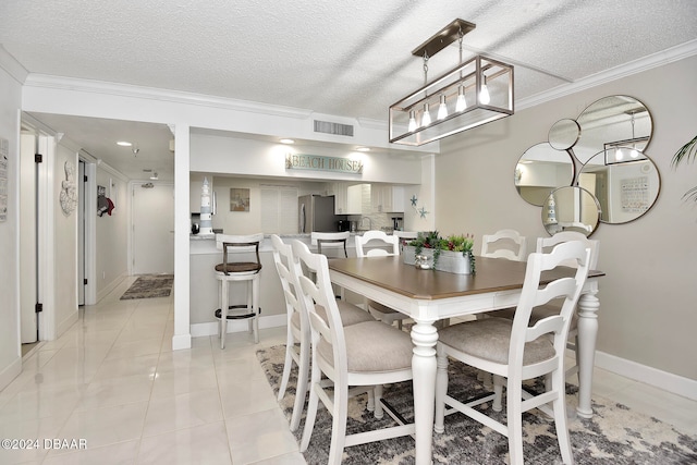 tiled dining area featuring a textured ceiling and ornamental molding