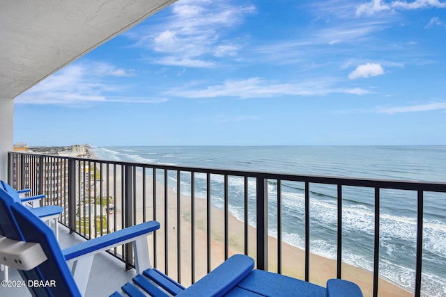 balcony with a water view and a view of the beach