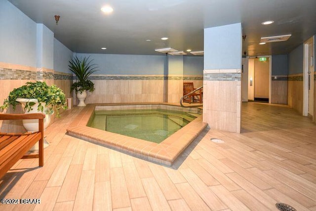 view of swimming pool with an indoor hot tub