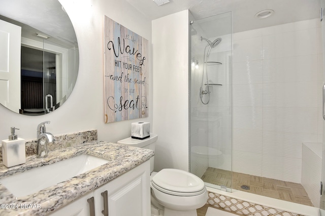 bathroom featuring tile patterned flooring, vanity, toilet, and a shower with door