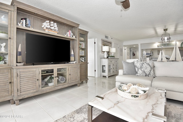 living room with light tile patterned floors, a textured ceiling, and ornamental molding