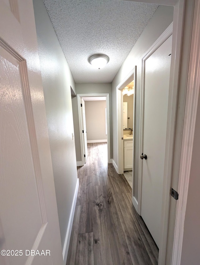 hall with dark wood-type flooring and a textured ceiling