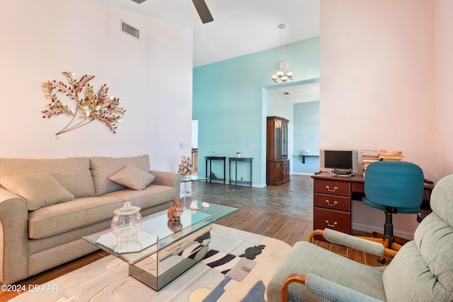 living room featuring hardwood / wood-style floors, a high ceiling, and ceiling fan with notable chandelier