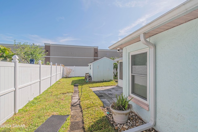 view of yard featuring a storage unit and a patio