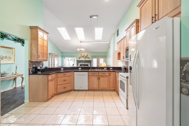 kitchen with sink, pendant lighting, white appliances, and vaulted ceiling