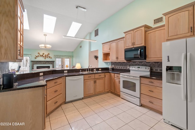 kitchen featuring light brown cabinets, hanging light fixtures, sink, and white appliances